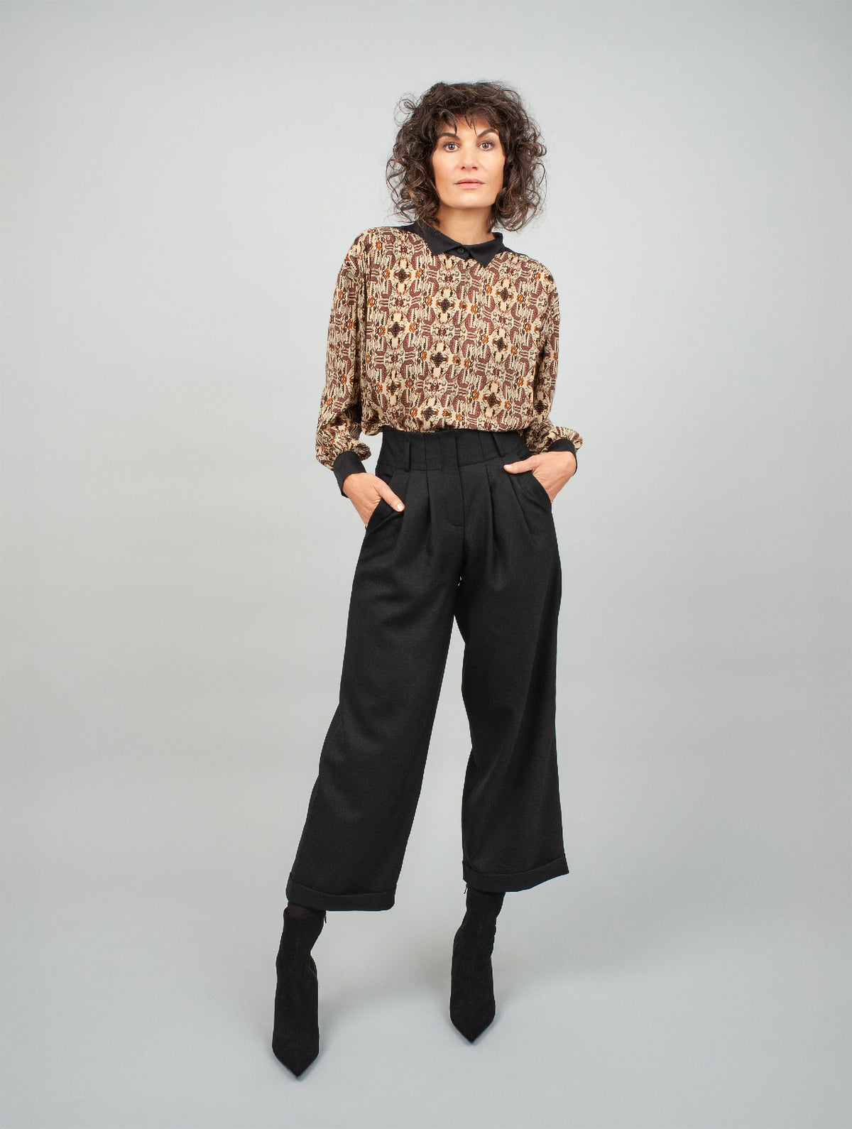Schwarze Woll-Culotte mit hohem Bund Bundfalten, seitlichen Taschen und kleinen Aufschlägen am Hosenbein