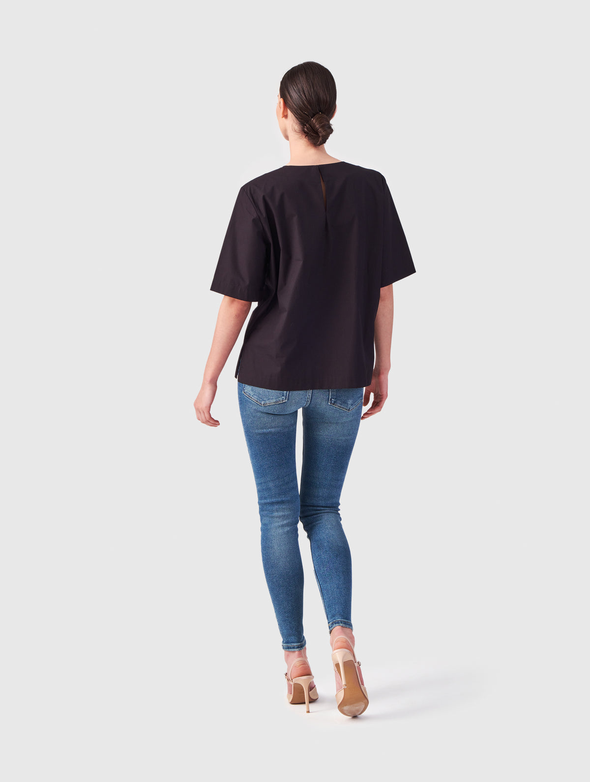 Hochgeschlossene Bluse aus Baumwolle im T-Shirt-Stil mit Knopfverschluss auf der Rückseite.