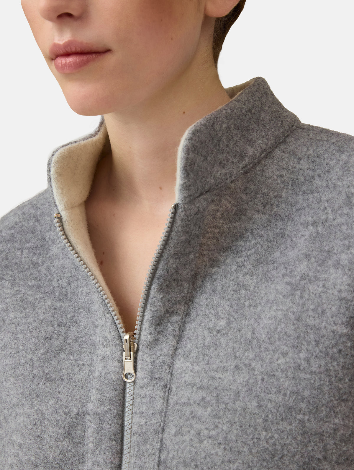 Wendbare Blousonjacke aus hochwertiger Merinowolle mit Stehkragen, Bündchen an den Ärmelenden und am Saumende, sowie seitlichen Leistentaschen auf der helleren Seite und großen aufgesetzten Taschen auf der dunkleren Seite. Dieses Modell ist Teil unserer REBORN-Linie und steht für unsere "Zero-Waste-Politik", da mit Stoff aus Altbestand gefertigt.