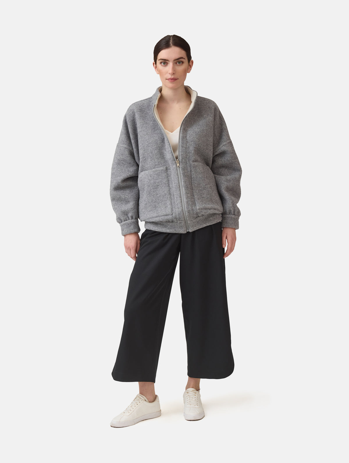 Wendbare Blousonjacke aus hochwertiger Merinowolle mit Stehkragen, Bündchen an den Ärmelenden und am Saumende, sowie seitlichen Leistentaschen auf der helleren Seite und großen aufgesetzten Taschen auf der dunkleren Seite. Dieses Modell ist Teil unserer REBORN-Linie und steht für unsere "Zero-Waste-Politik", da mit Stoff aus Altbestand gefertigt.