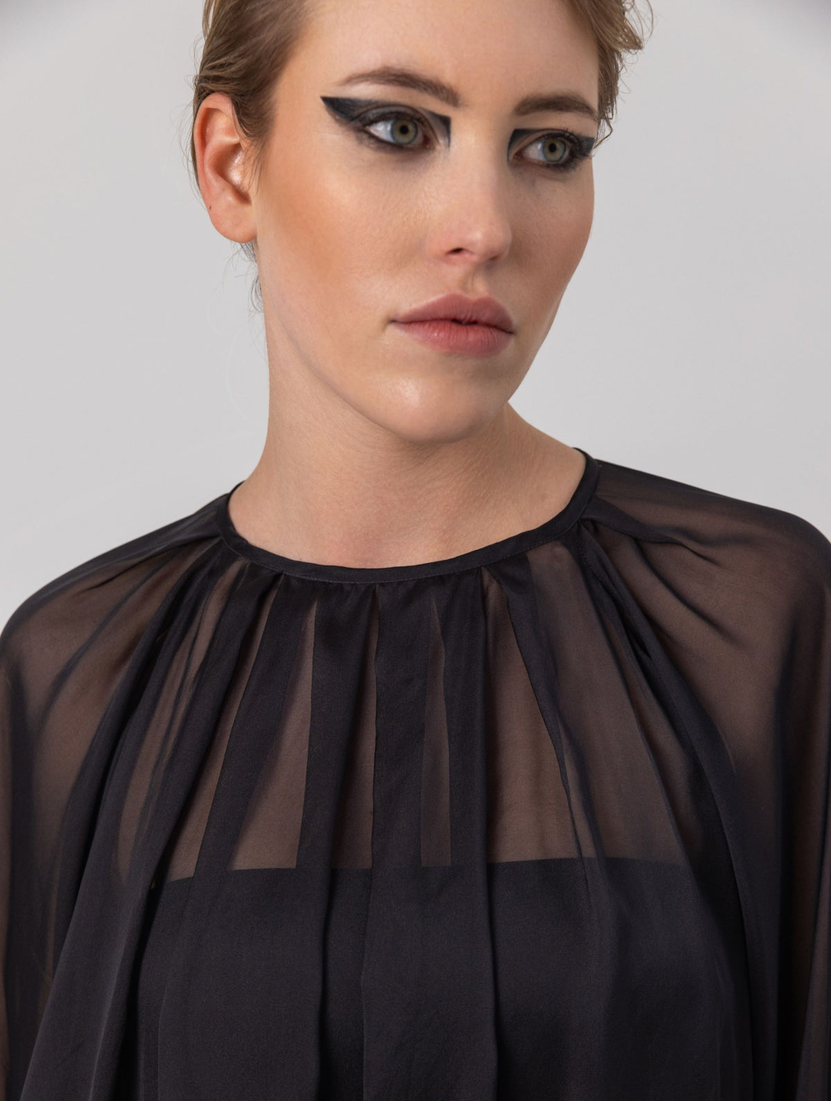 Weite Bluse mit Rundhalsausschnitt, Falten auf der Vorder- und Rückseite und Raglan-Dichterärmeln. Dieses Modell ist Teil unserer REBORN-Kollektion und steht für unsere "Zero-Waste-Politik".
