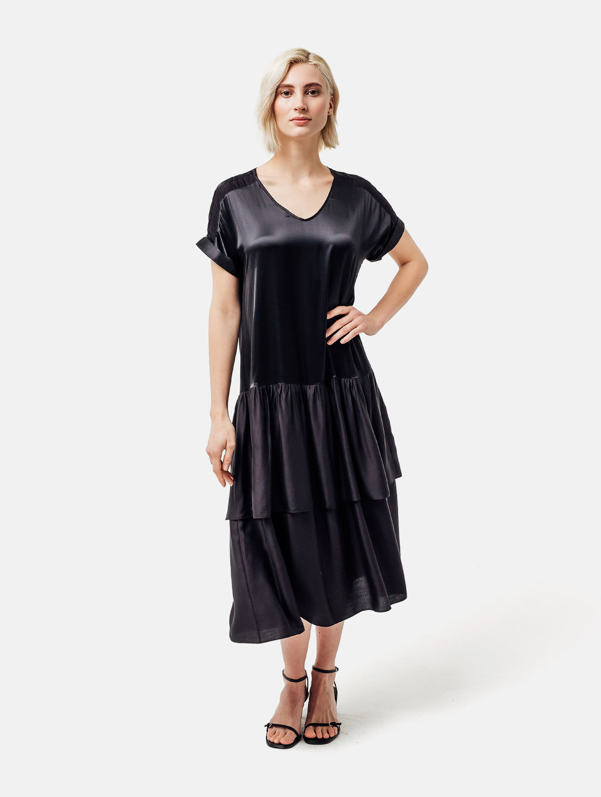 Locker fallendes Kurzarmkleid mit V-Ausschnitt und Volantrock aus Seidensatin und Viskose. Dieses Produkt ist Teil unserer Reborn Linie.