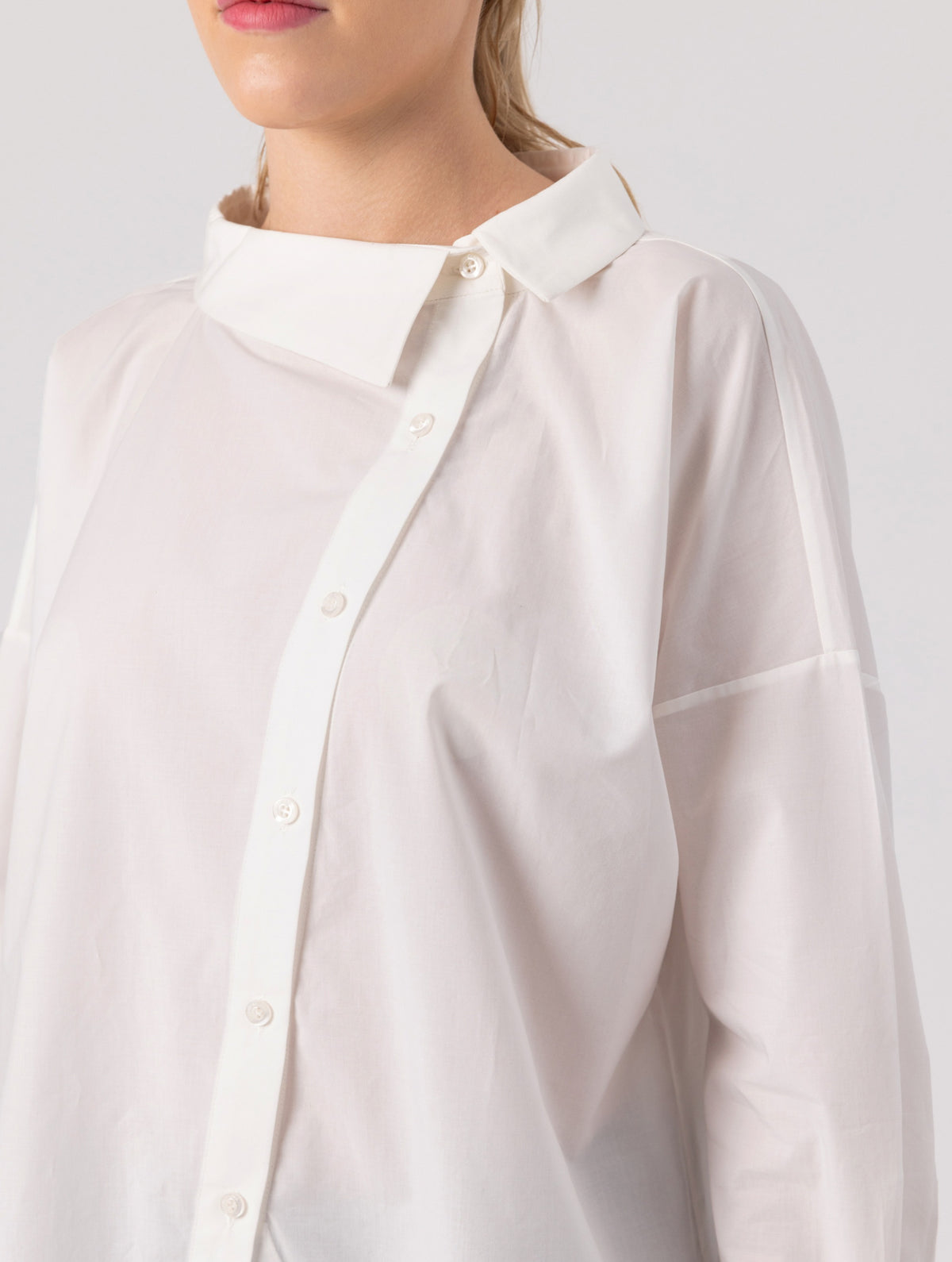 Locker geschnittene Bluse mit Stehkragen und schräger Knopfleiste auf der Vorderseite. Hergestellt aus Naturfasern.