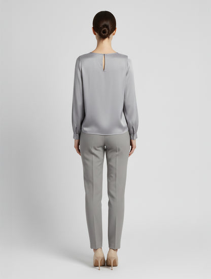Langarm Seidenbluse mit Rundhalsausschnitt und Knopf im Nackenbereich.