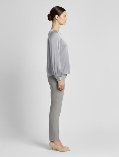 Langarm Seidenbluse mit Rundhalsausschnitt und Knopf im Nackenbereich.
