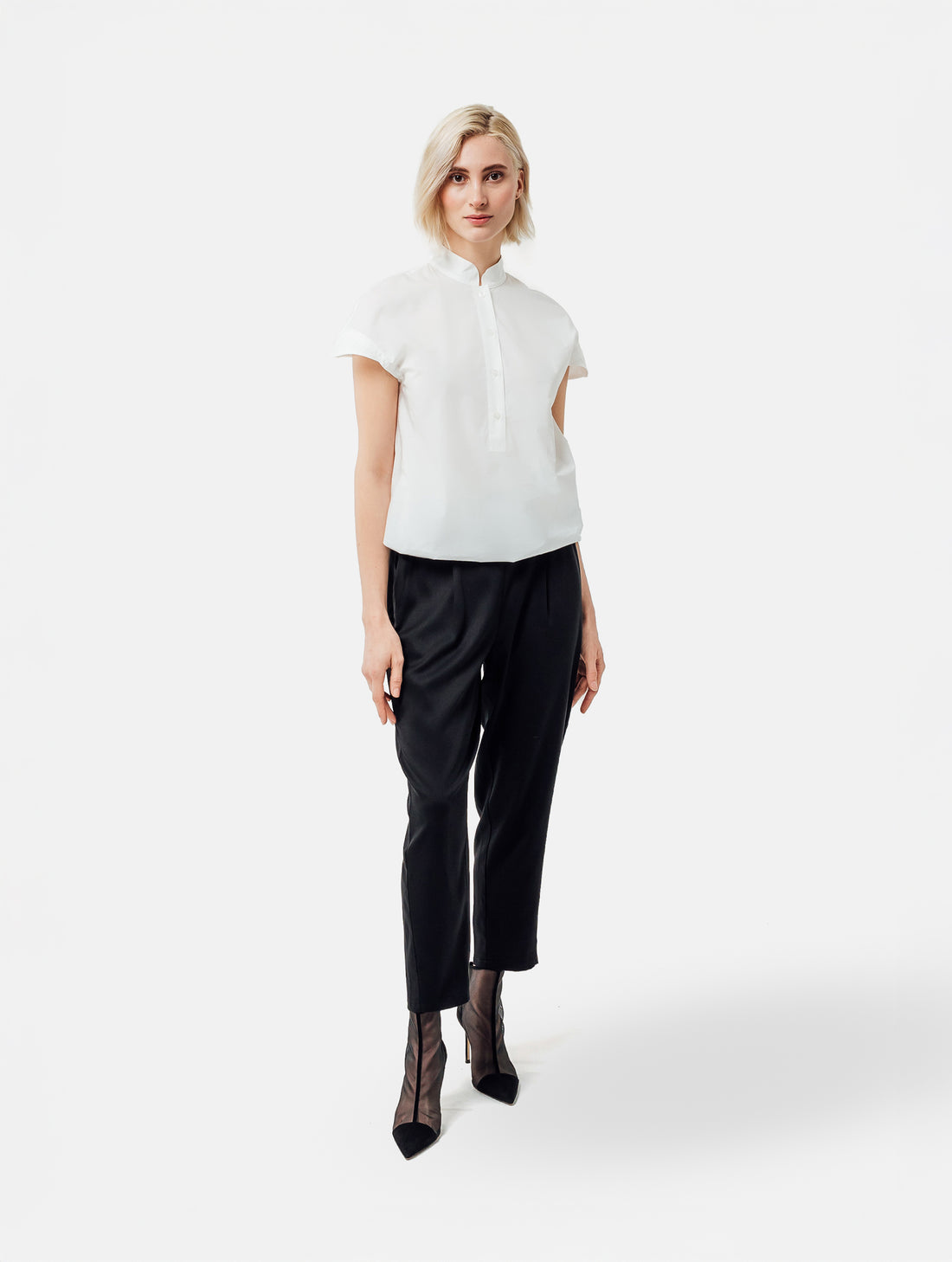 Bluse aus 100% feiner Baumwolle, kleinem Stehkragen, verkürzter Knopfleiste und einem elastischem Bund am Saumende.