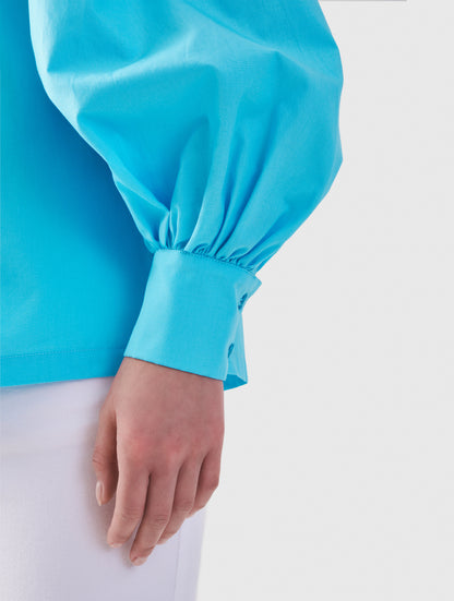 Hochgeschlossene Bluse aus Baumwolle mit weiten Bischofsärmel und Volant-Detail an der Schulternaht, sowie feinen Biesen an der Schulter, wie auch Biesen am Kragen auf der Vorderseite. Aus nachhaltiger Baumwolle gefertigt.