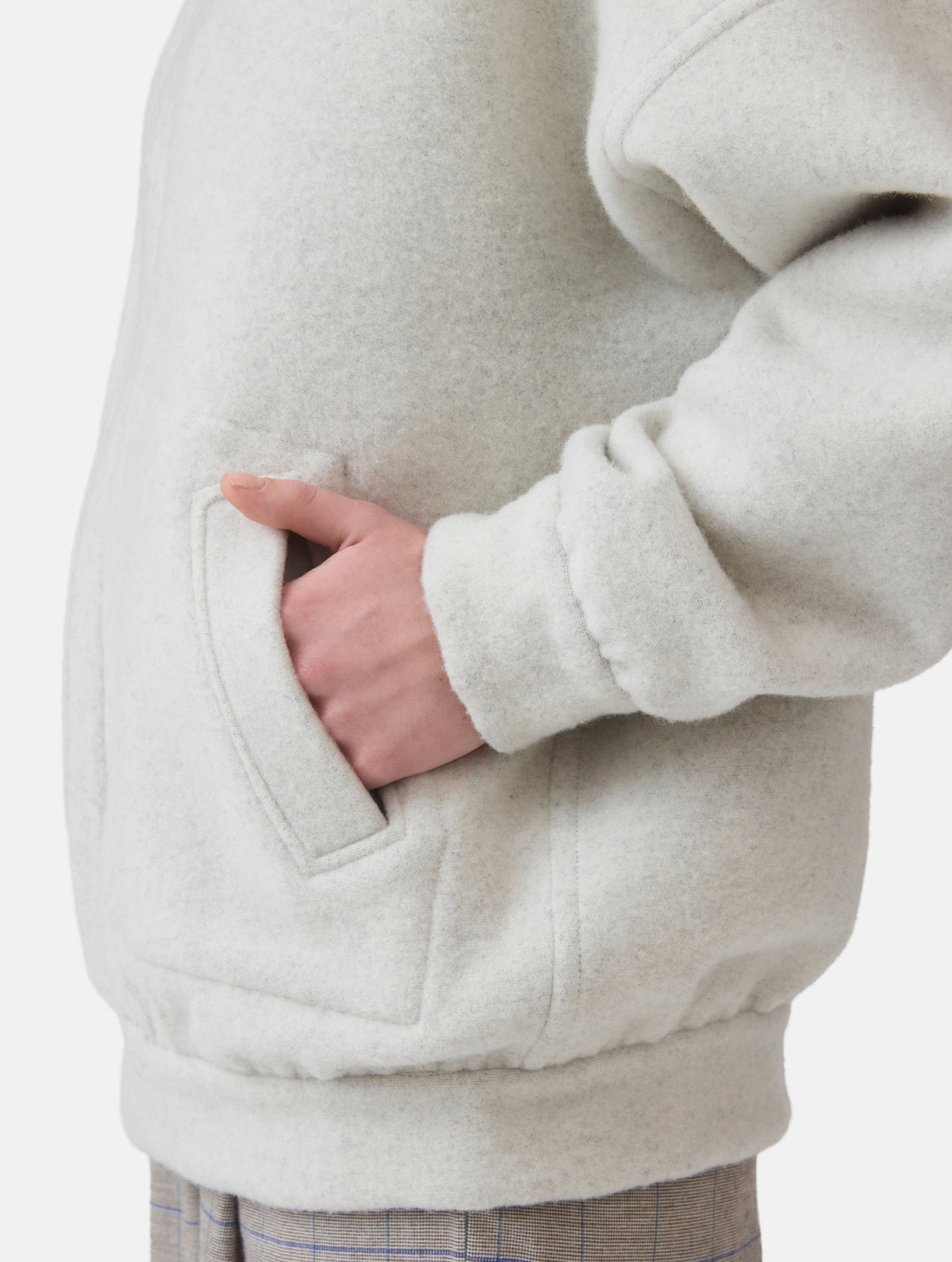 Wendbare Blousonjacke aus hochwertiger Merinowolle mit Stehkragen, Bündchen an den Ärmelenden und am Saumende, sowie seitlichen Leistentaschen auf der helleren Seite und großen aufgesetzten Taschen auf der dunkleren Seite. Dieses Modell ist Teil unserer REBORN-Linie und steht für unsere "Zero-Waste-Politik", da mit Stoff aus Altbestand gefertigt.