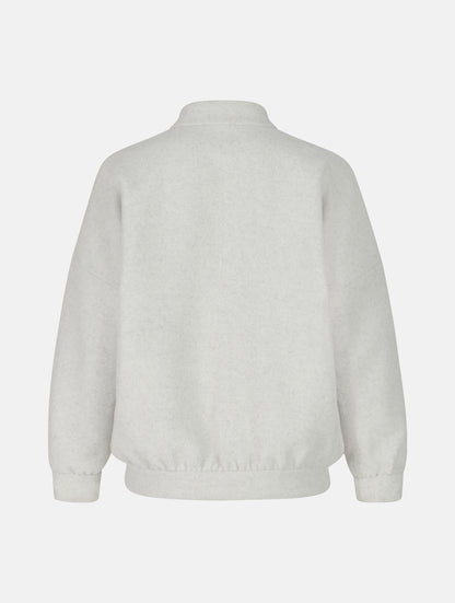 Wendbare Blousonjacke aus hochwertiger Merinowolle mit Stehkragen, Bündchen an den Ärmelenden und am Saumende, sowie seitlichen Leistentaschen auf der helleren Seite und großen aufgesetzten Taschen auf der dunkleren Seite. Dieses Modell ist Teil unserer REBORN-Linie und steht für unsere "Zero-Waste-Politik", da mit Stoff aus Altbestand gefertigt.
