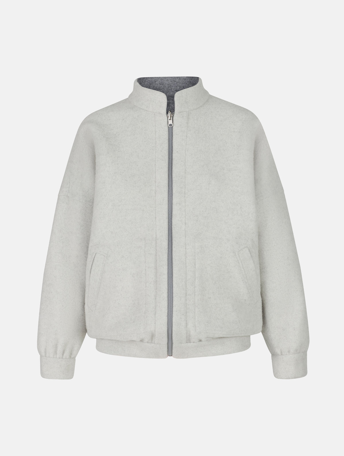Wendbare Blousonjacke aus hochwertiger Merinowolle mit Stehkragen, Bündchen an den Ärmelenden und am Saumende, sowie seitlichen Leistentaschen auf der helleren Seite und großen aufgesetzten Taschen auf der dunkleren Seite. Dieses Modell ist Teil unserer REBORN-Linie und steht für unsere "Zero-Waste-Politik", da mit Stoff aus Altbestand gefertigt.