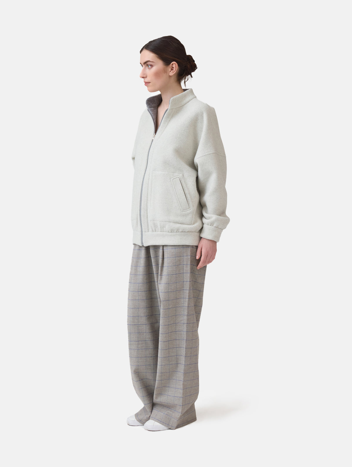 Wendbare Blousonjacke aus hochwertiger Merinowolle mit Stehkragen, Bündchen an den Ärmelenden und am Saumende, sowie seitlichen Leistentaschen auf der helleren Seite und großen aufgesetzten Taschen auf der dunkleren Seite. Dieses Modell ist Teil unserer REBORN-Linie und steht für unsere "Zero-Waste-Politik", da mit Stoff aus Altbestand gefertigt.