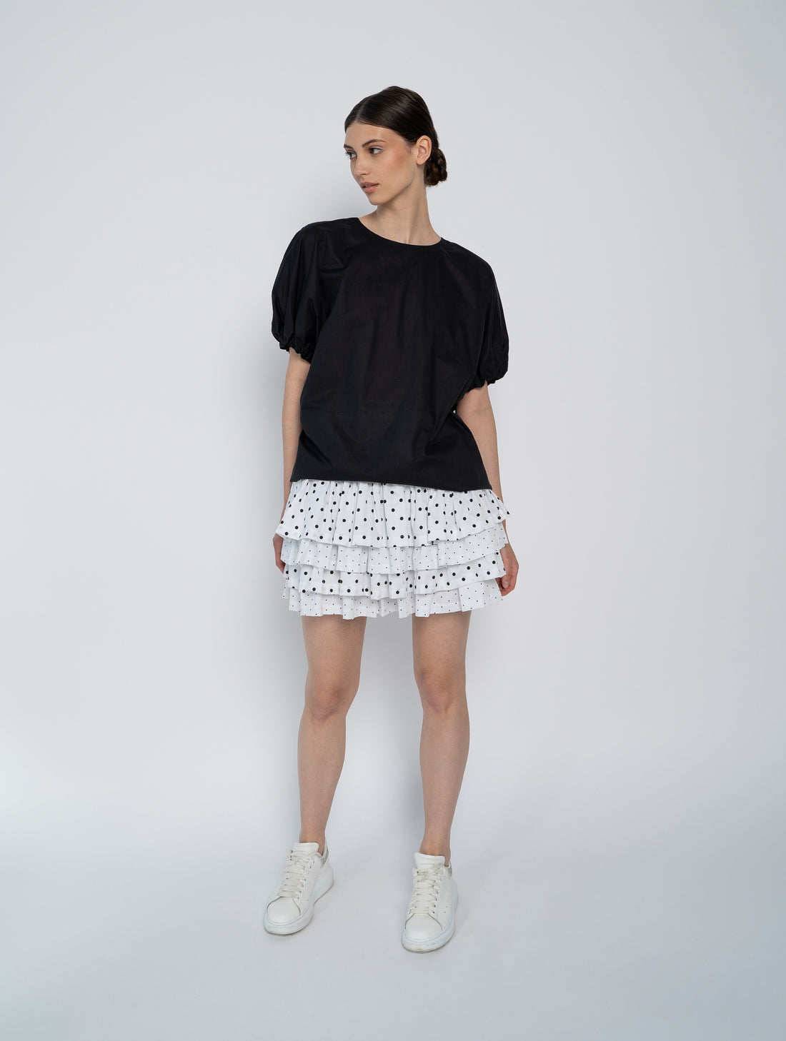 Schwarze, weite Bluse mit kurzen Rüschenärmeln aus Biobaumwolle.