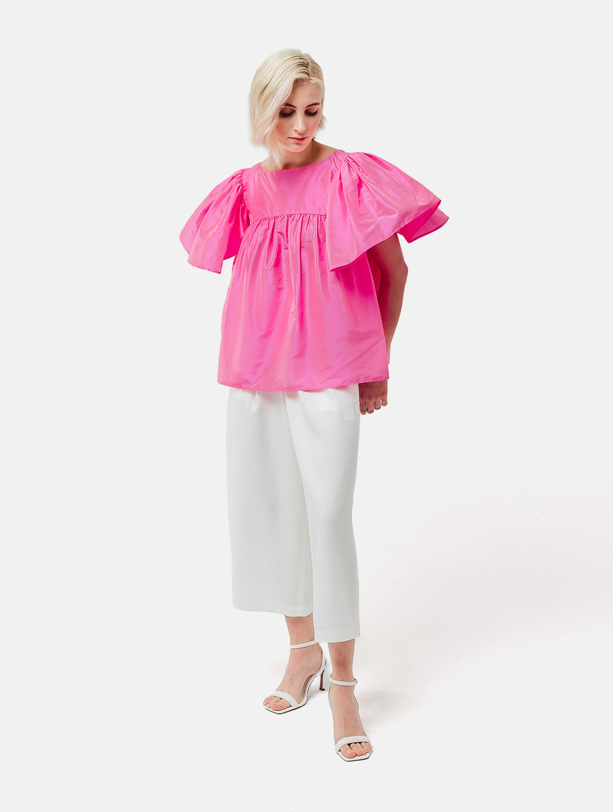 Weit geschnittene Bluse mit breitem Volantärmel und raffiniertem Rückenausschnitt aus pinken Dupionsilk, sowie versteckten Taschen in der Seitennaht. Zusätzlich mit breiten Gürtel zum Binden tragbar. Dieses Produkt ist Teil unserer Reborn Linie.