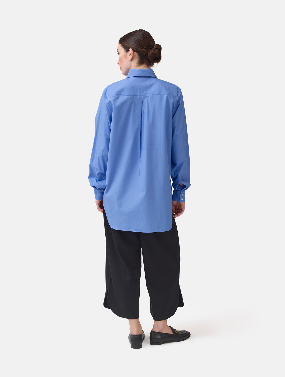 Langes Oversize Blusenhemd mit klassischem Hemdkragen und Manschetten, sowie zwei aufgesetzten Brutstaschen und abgerundeten Saumende im Rückteil.  Dieses Modell ist Teil unserer REBORN-Linie und steht für unsere "Zero-Waste-Politik", da mit Stoff aus Altbestand gefertigt.