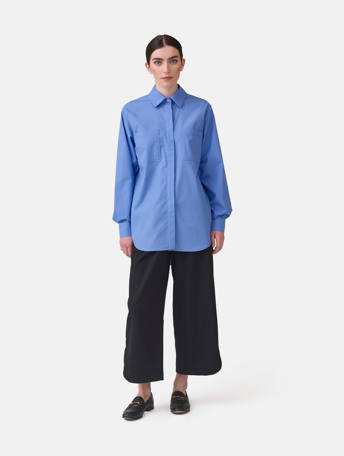 Langes Oversize Blusenhemd mit klassischem Hemdkragen und Manschetten, sowie zwei aufgesetzten Brutstaschen und abgerundeten Saumende im Rückteil.  Dieses Modell ist Teil unserer REBORN-Linie und steht für unsere "Zero-Waste-Politik", da mit Stoff aus Altbestand gefertigt.