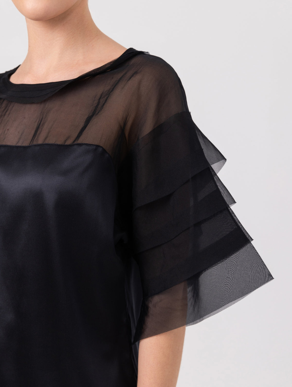 Exquisite Kurzarmbluse aus Stretch-Satin mit eleganten Einsätzen in der Schulterpartie und den Ärmeln aus feiner Organzaseide.