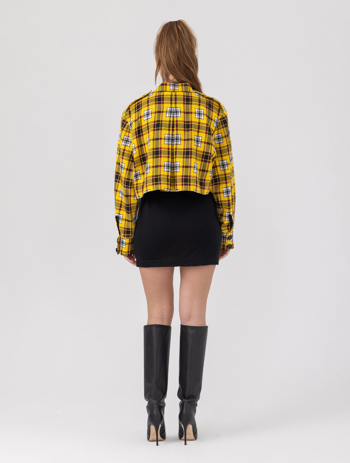 Doppelseitige Karo-Kurzjacke mit abnehmbaren Schulterpolstern, eingesetzten Ärmeln mit Ärmelgürteln und Schulterklappen sowie vorderen Halbpasse. Die Jacke kann von beiden Seiten getragen werden.   Hergestellt aus Naturfasern. 