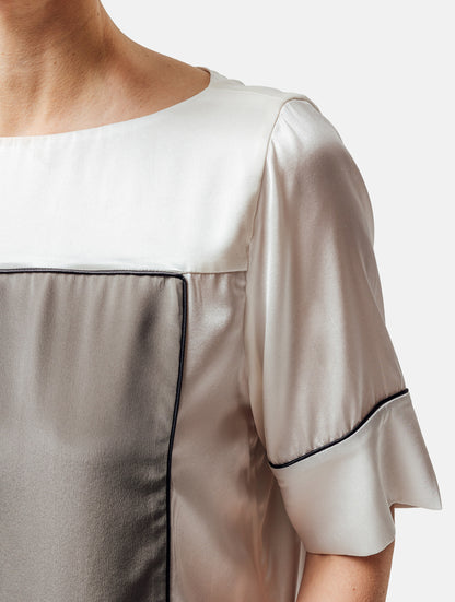 Zweifarbiges, locker geschnittenes Shirt mit weitem Halsauschnitt und schwarzem Piping Detail. Stoffe kommen aus dem Altbestand der Firma, daher nachhaltig.