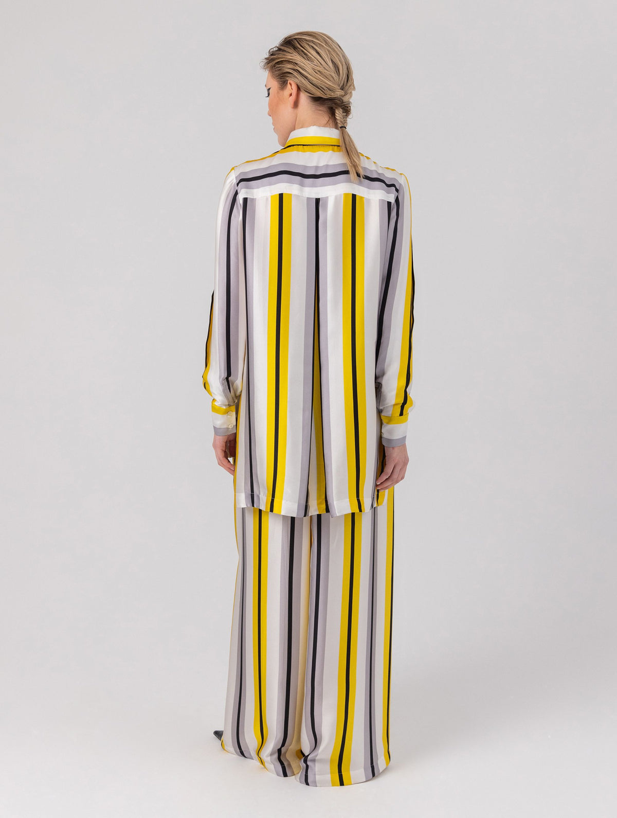 Bedruckte Oversize-Seidenbluse aus Satin mit Hemdkragen, aufgesetzten Taschen auf der Vorderseite und Kellerfalte auf der Rückseite sowie schwarzem Chiffonschal.  Hergestellt aus Naturfasern, sowie Stoffen aus unserem Altbestand im Sinne unserer "Zero-Waste-Politik".
